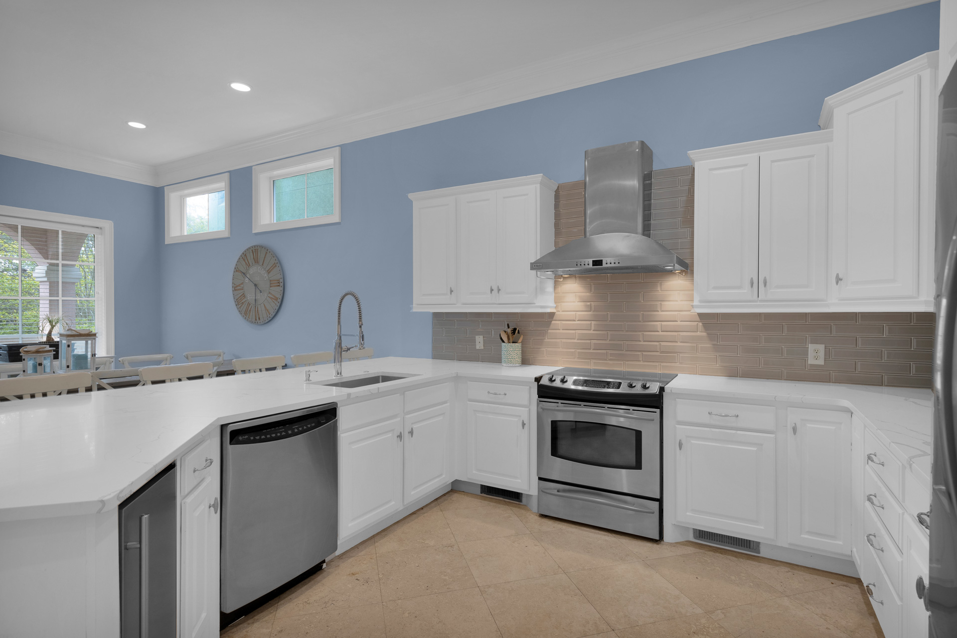 Kitchen with stainless range, vent hood and white cabinets